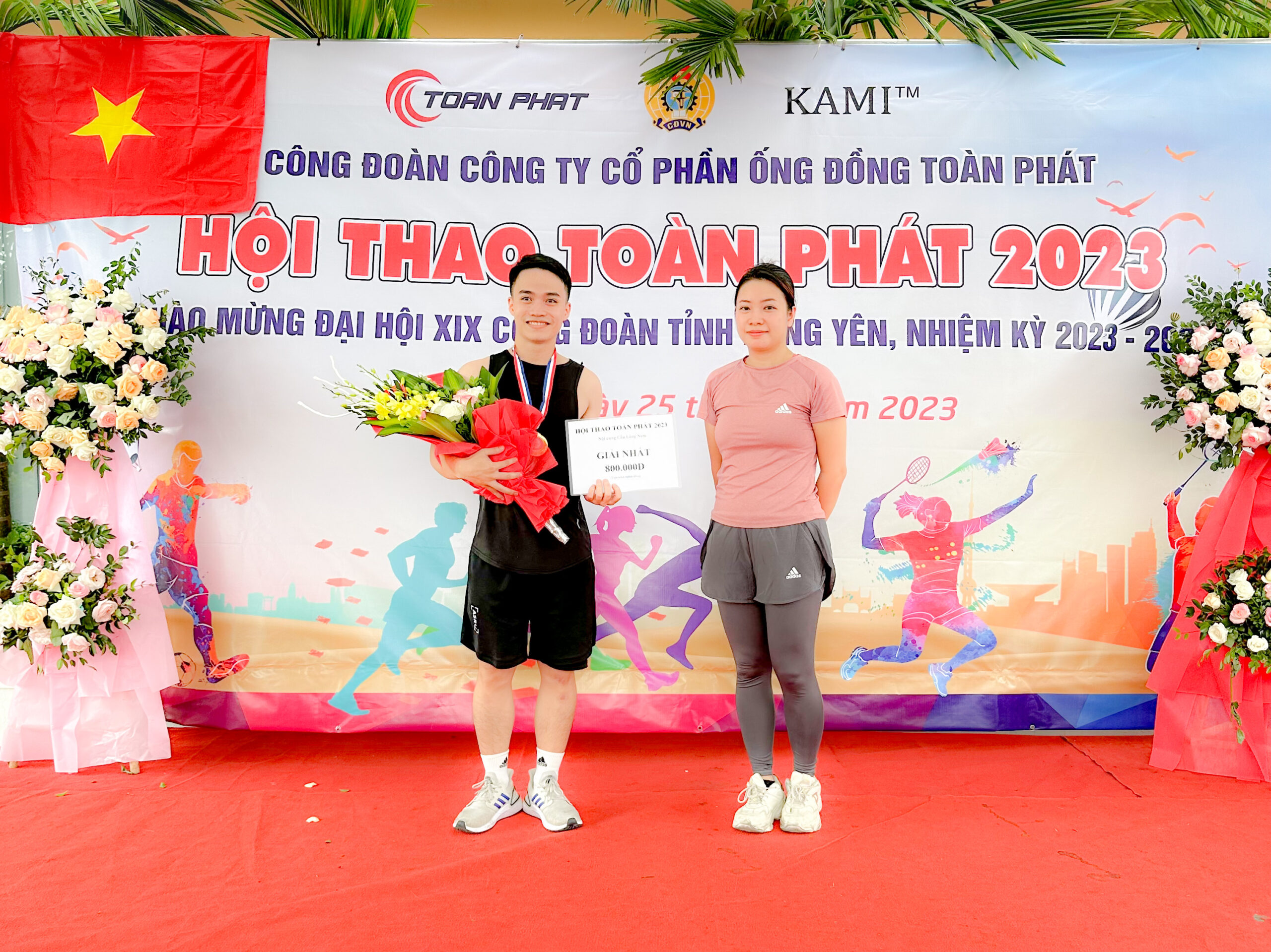 Bà Đào Thu Trang - Phó Tổng giám đốc công ty (bên phải) trao giải Nhất môn Cầu lông Nam cho anh Lê Minh Chính