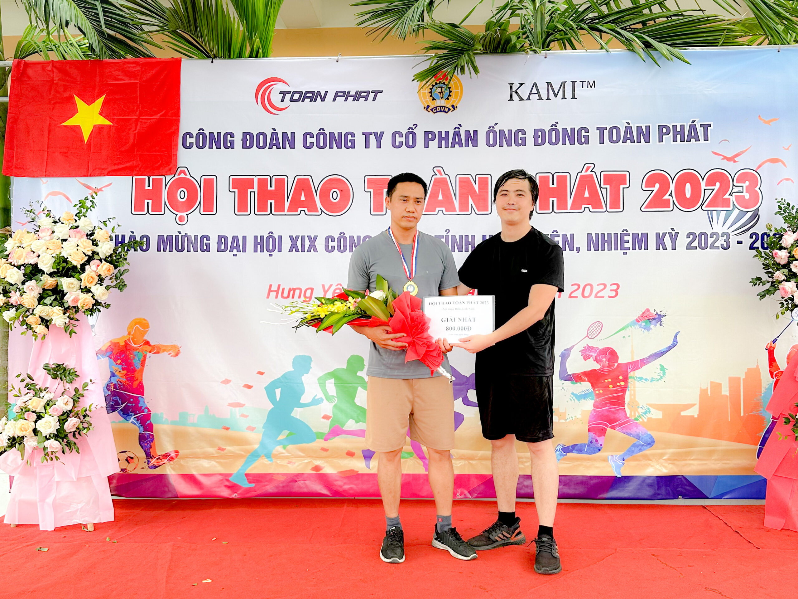 Ông Bùi Hồng Phúc - Tổng Giám đốc công ty (bên phải) trao Giải nhất điền kinh Nam cho anh Trần Đăng Vũ phòng QA/QC với thành tích 14 phút 19 giây
